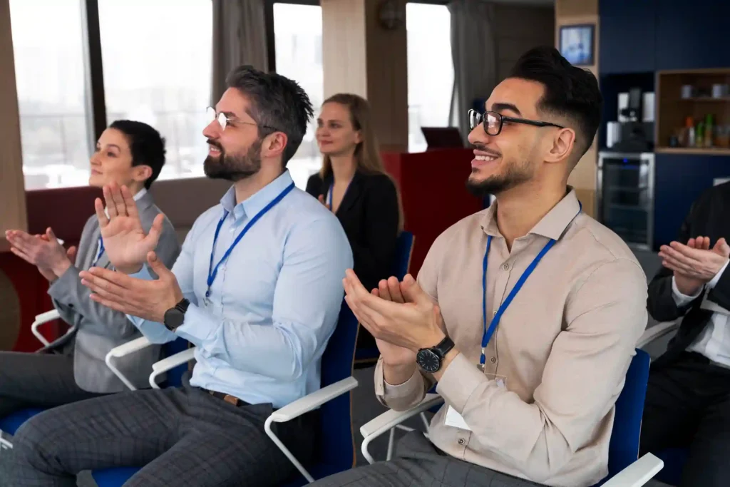 Personas aplaudiendo en una conferencia sobre sostenibilidad en eventos empresariales 